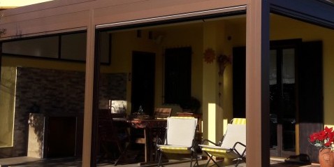 Pergole Gibus-MED QUADRA a due moduli indipendenti. Chiusure laterali motorizzate CLICK ZIP TWIN composte da telo Cristal trasparente per protezione invernale e telo ombreggiante Soltis per la protezione solare. Timpano superiore in policarbonato. Motori ed automatismi SOMFY.